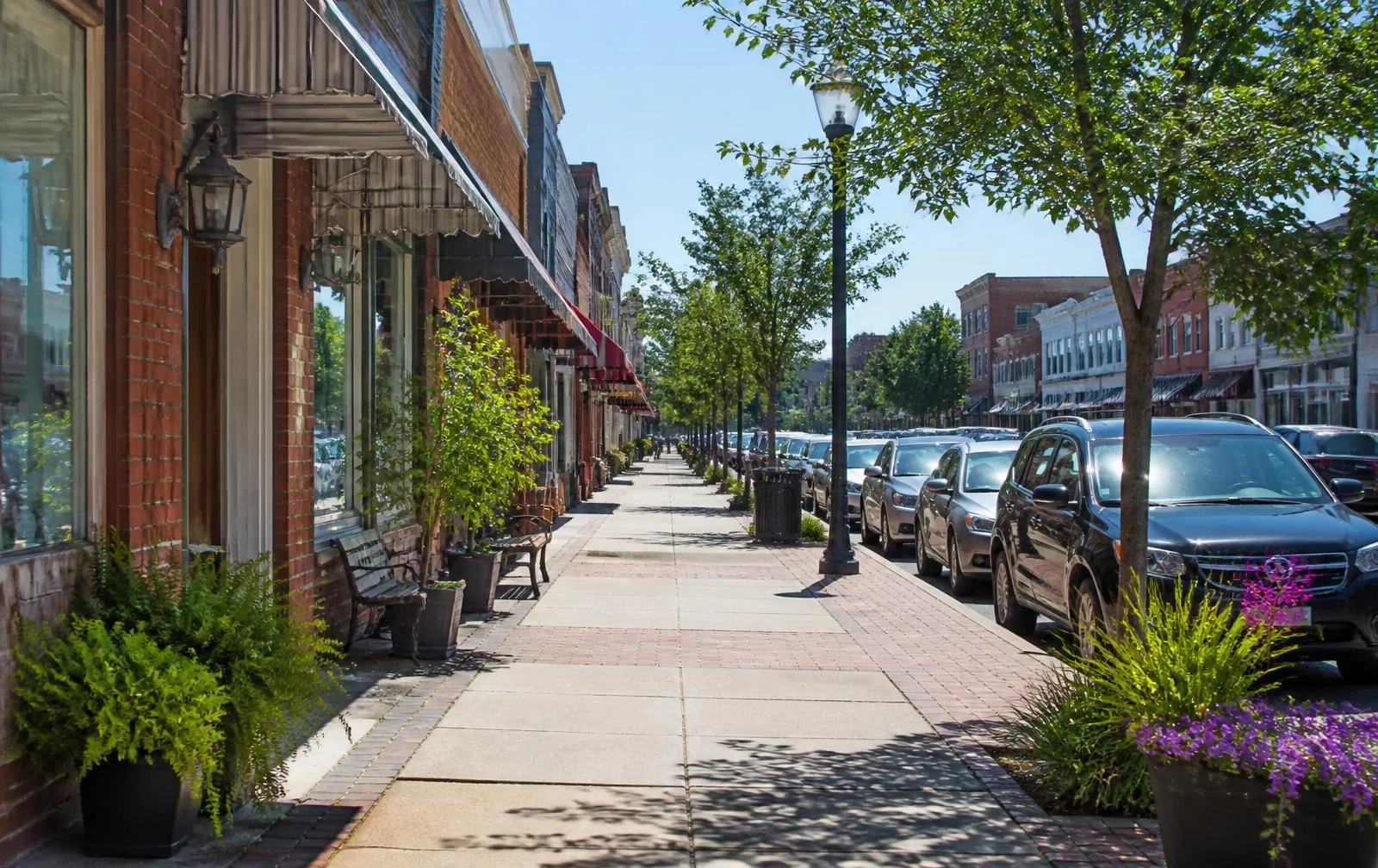 Restored brick storefronts along a small-town Southern main street on a bright morning