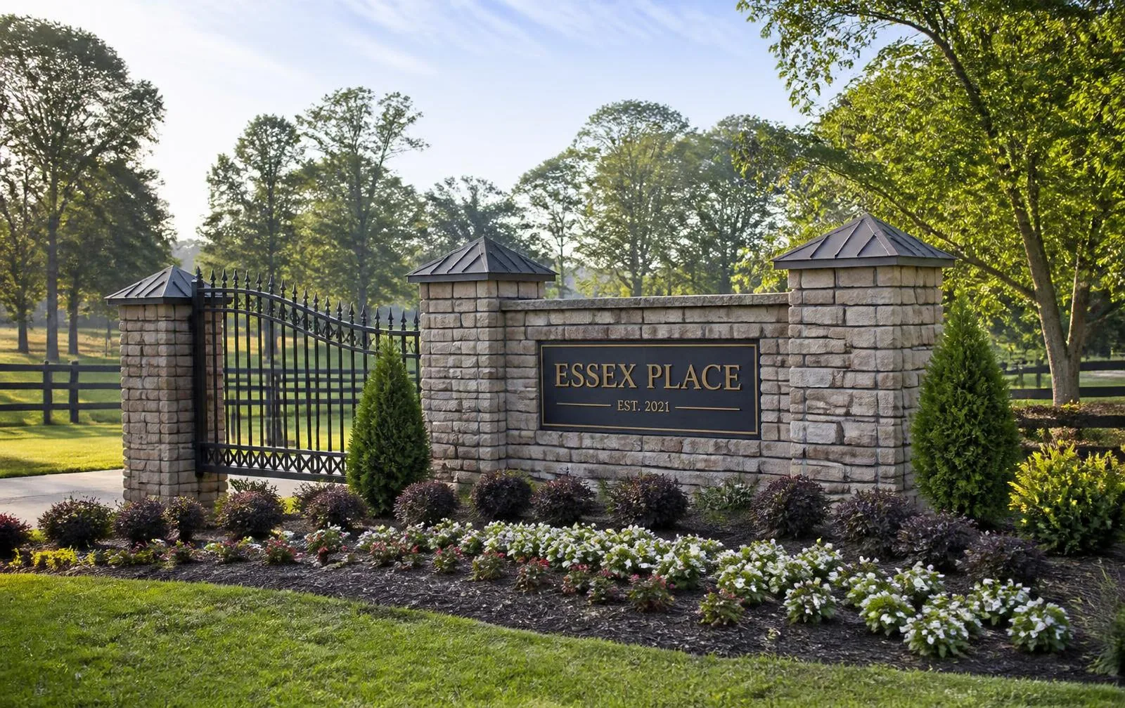 Stone and iron gated entrance monument with landscaped beds at a Waxhaw area residential community